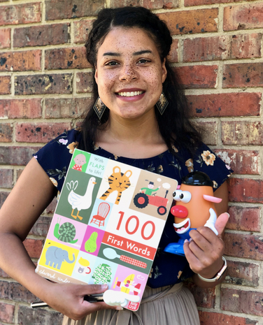 A Tallahassee Florida speech therapist and language therapist holding therapy materials of Mr potato head and 100 first words book to increase child development 